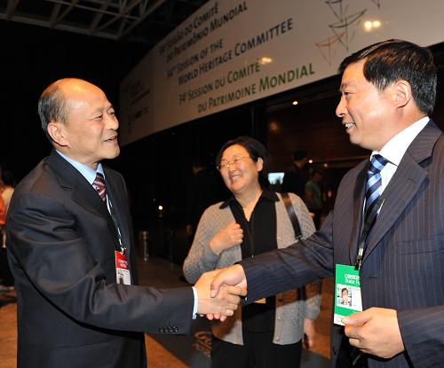 7月31日,在巴西首都巴西利亚,中国代表团团长、国家文物局副局长童明康(左)向河南代表团表示庆祝。在巴西首都巴西利亚举行的第34届世界遗产大会31日正式将中国登封“天地之中”历史建筑群列入《世界遗产名录》。 新华社记者 宋为伟 摄 “中国丹霞”经批准被正式列入《世界遗产名录》